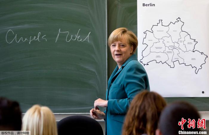 (图五)资料图：当地时间2013年8月13日，德国柏林，德国总理默克尔造访一所高中，向学生们讲述柏林墙的建设情况。当天是柏林墙建成52周年纪念日。